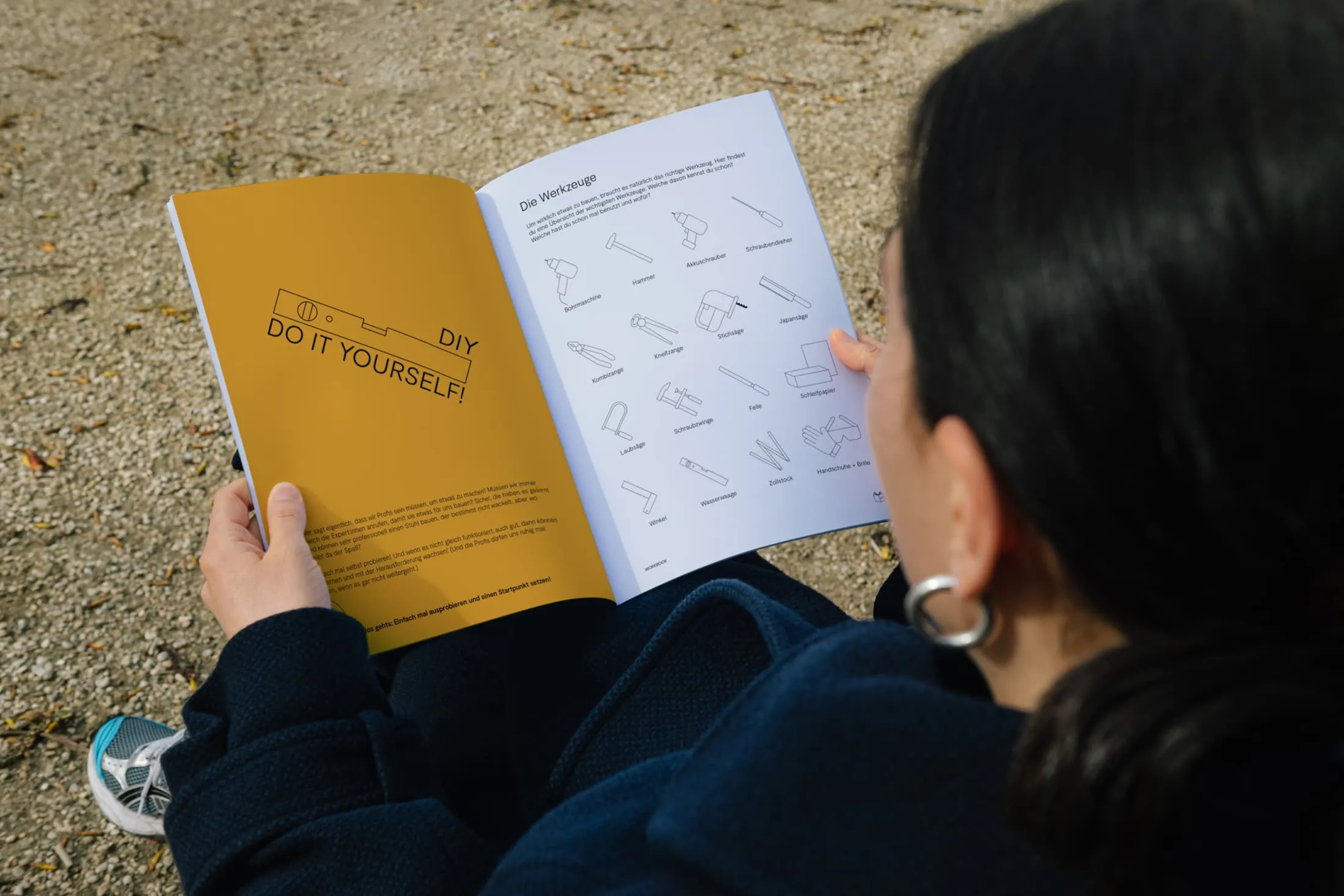 Jugendliche liest im HORNBACH-macht-Schule-Workbook die Übersicht der Werkzeuge